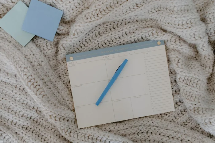 Weekly Quran memorization planner and pen used to track a student’s Hifz revision progress